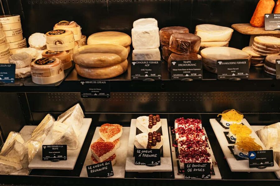 Paris: Gourmet Food Tour with Over 10 Tastings and Wine - The cheese shop where the food lesson gets more serious